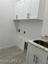 Washroom with cabinet space, hookup for a washing machine, and electric dryer hookup
