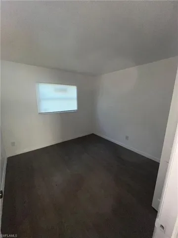 Unfurnished room with a textured ceiling and baseboards