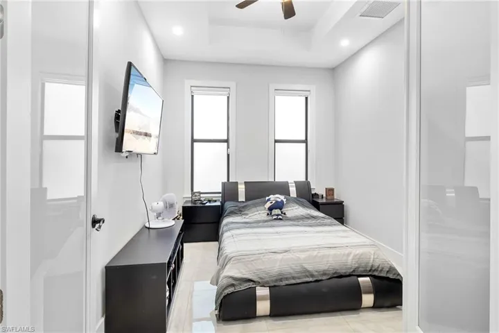 Bedroom featuring recessed lighting, a ceiling fan, and a tray ceiling