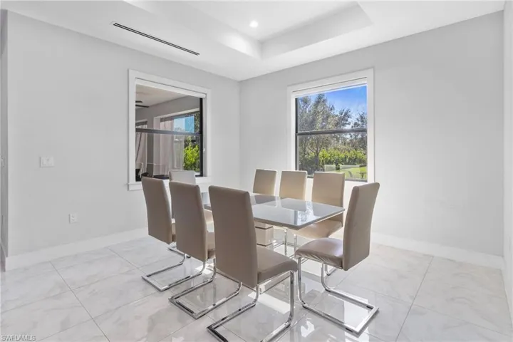 Dining area with a raised ceiling and recessed lighting