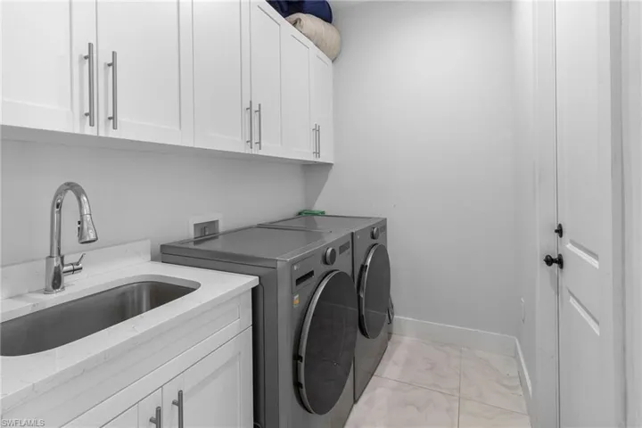Laundry area featuring independent washer and dryer and cabinet space