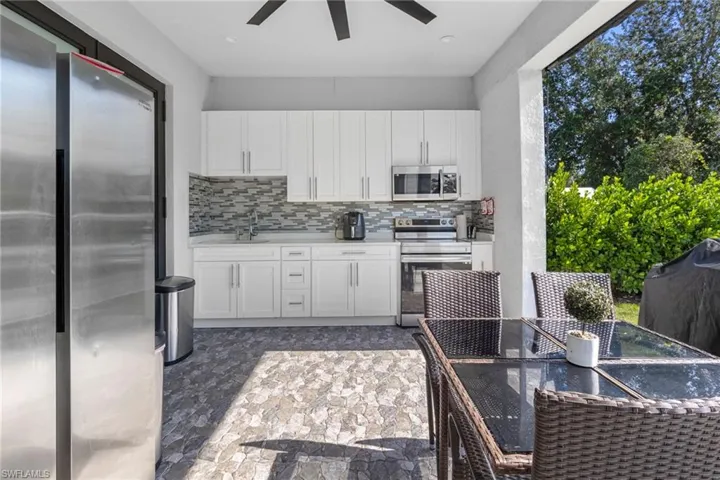Kitchen featuring stainless steel appliances, white cabinetry, and tasteful backsplash