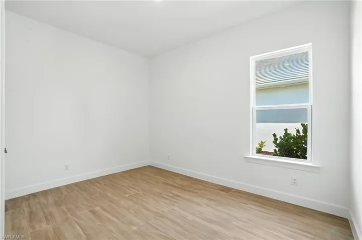 Unfurnished room featuring light wood-type flooring and baseboards