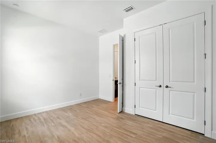 Unfurnished bedroom featuring light wood finished floors and a closet