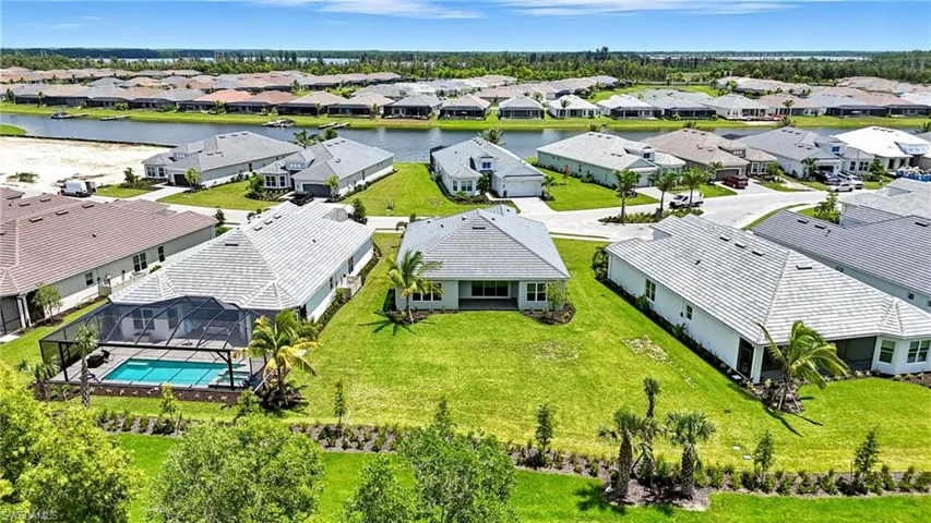 Aerial perspective of suburban area featuring a large body of water and a pool