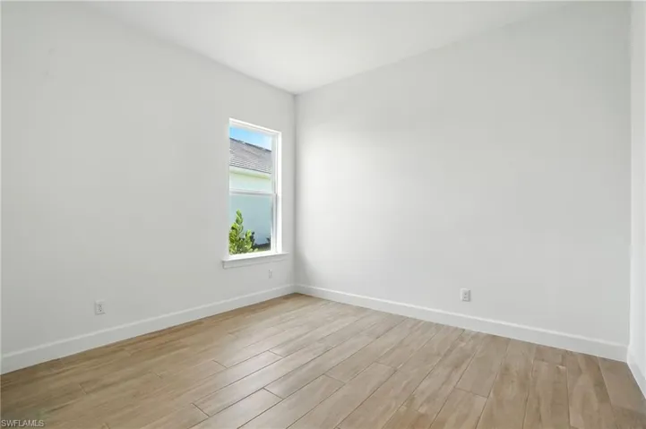 Empty room with baseboards and light wood-style flooring