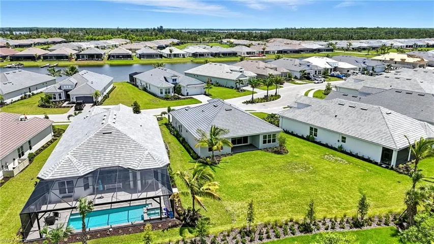 Aerial view of residential area featuring a large body of water and a pool