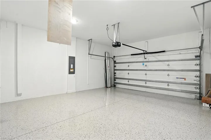 Garage with electric panel and a garage door opener