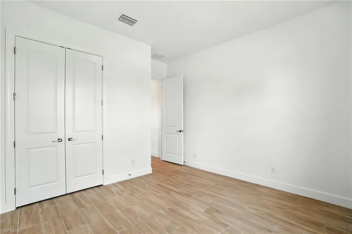 Unfurnished bedroom featuring light wood-type flooring and a closet