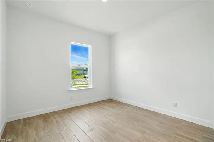 Spare room featuring baseboards and light wood finished floors