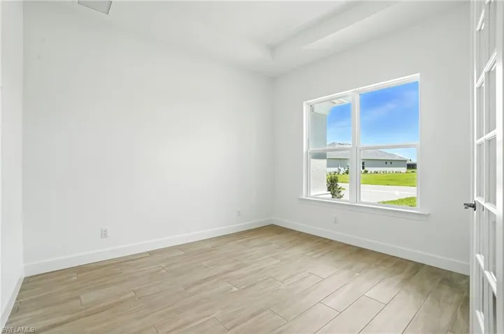 Unfurnished room with light wood-type flooring and baseboards