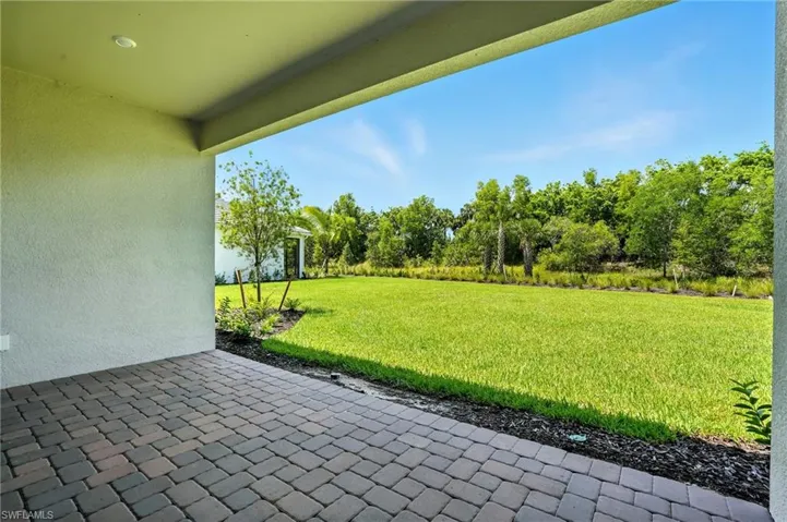 View of green lawn with a patio