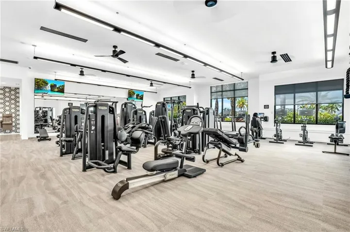 Gym with light colored carpet and a ceiling fan