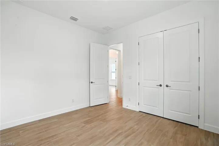 Unfurnished bedroom with light wood-style flooring and a closet