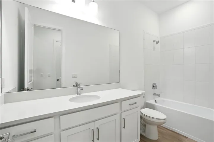 Full bath with  shower combination, vanity, and light wood-type flooring