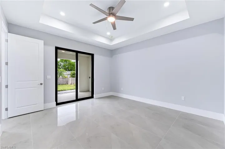 Spare room with ceiling fan and a tray ceiling