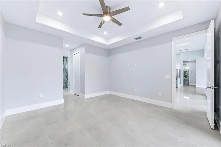 Unfurnished room with a tray ceiling and ceiling fan