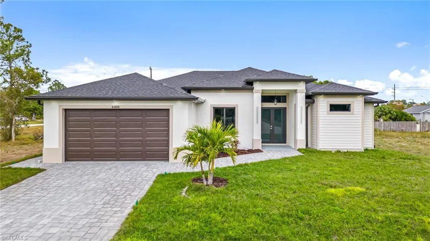 View of front facade featuring a front yard and a garage