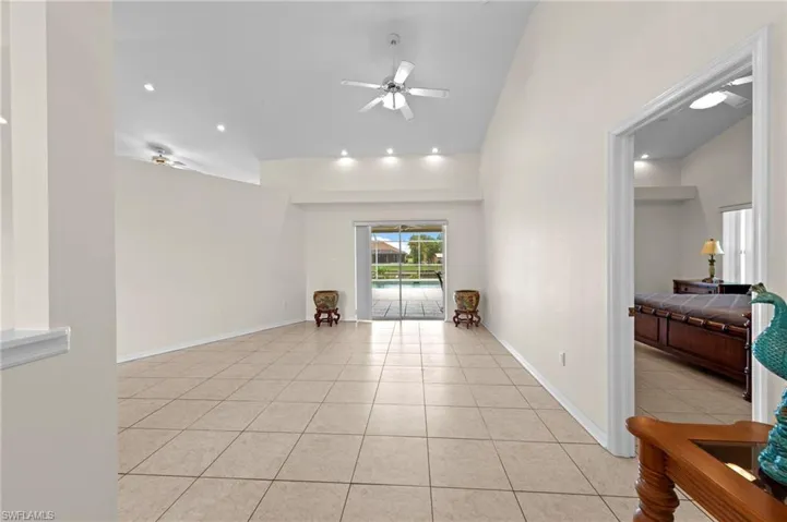 Unfurnished room with light tile patterned flooring, a ceiling fan, vaulted ceiling, and recessed lighting