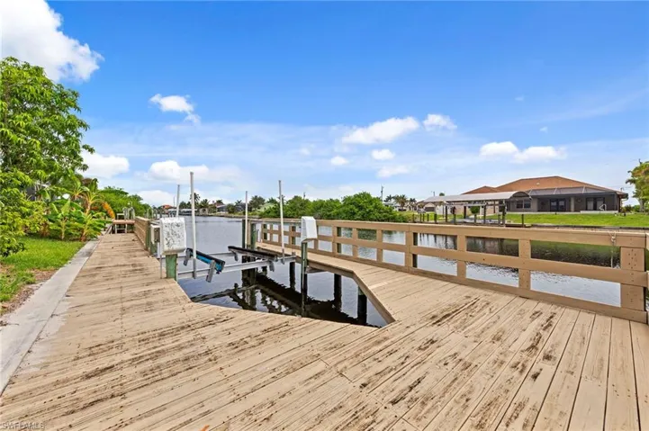 Dock area featuring boat lift and a water view