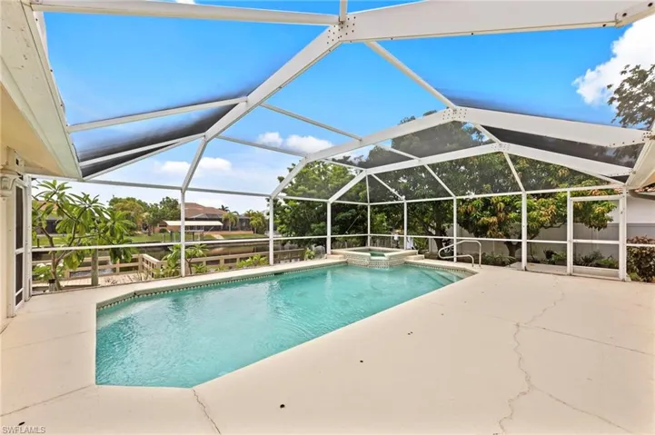View of pool with a patio, a pool with connected hot tub, and a lanai