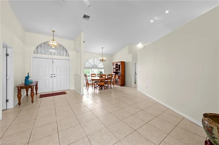 Foyer featuring a chandelier, light tile patterned floors, recessed lighting, and high vaulted ceiling