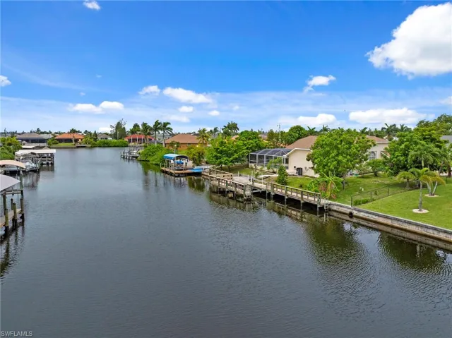 Water view with a dock and nearby suburban area