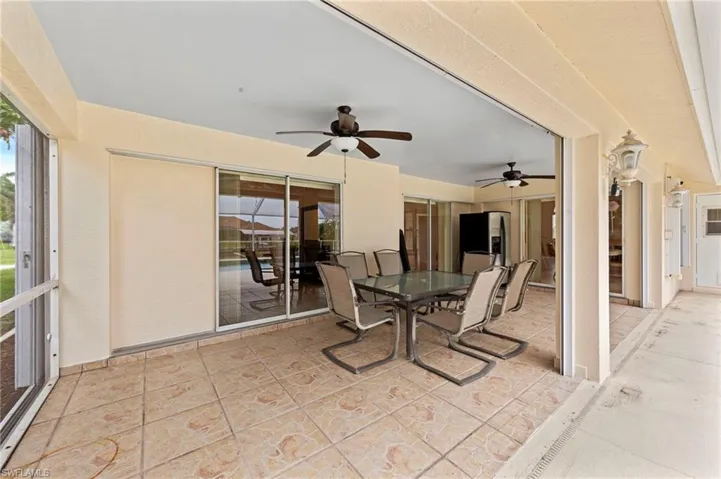 Sunroom / solarium with a ceiling fan and outdoor dining area