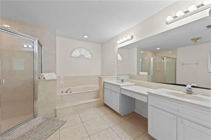 Bathroom featuring double vanity, tile patterned flooring, a bath, and a shower stall