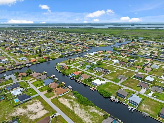 Aerial view of property's location with a large body of water and nearby suburban area