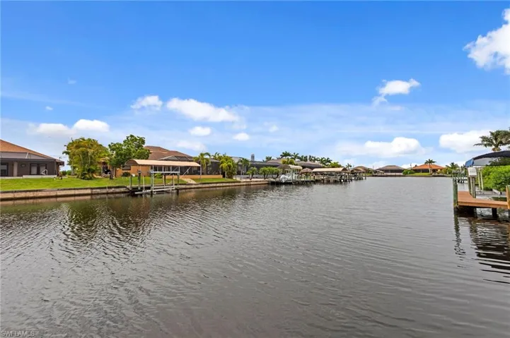 Water view with a dock and nearby suburban area