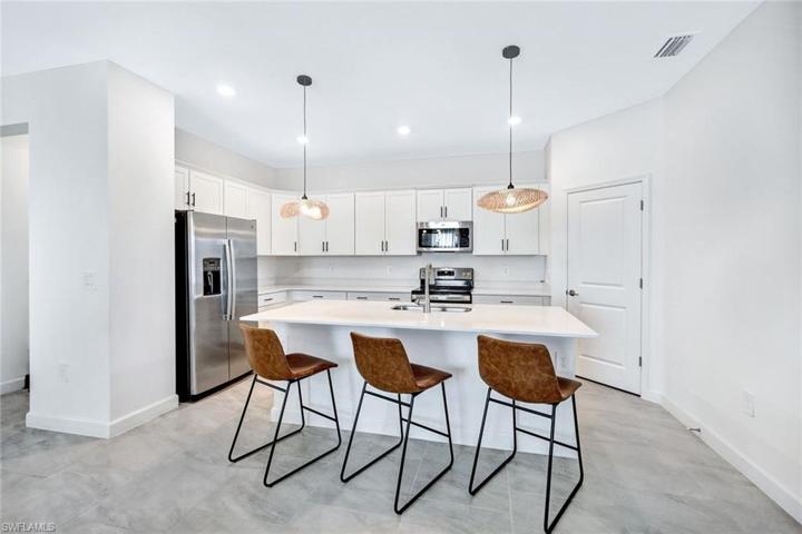 Stainless appliances, large island, and pantry with so much storage.