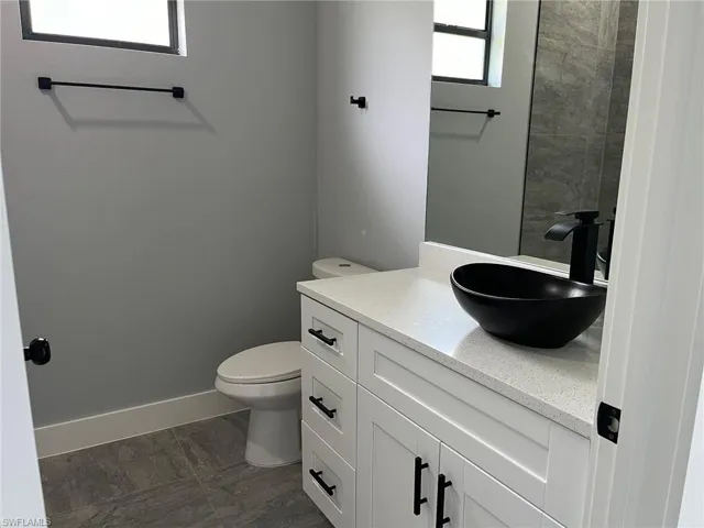 Bathroom featuring toilet, vanity, and tile patterned floors
