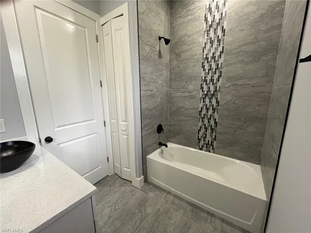 Bathroom with vanity and tiled shower / bath combo