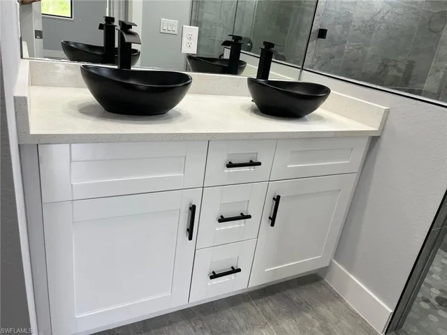 Room details with hardwood / wood-style floors, vanity, and a shower with shower door
