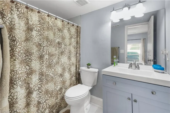 Bathroom featuring vanity, a shower with shower curtain, tile patterned flooring, and a textured wall