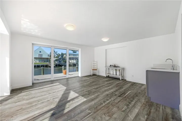 Unfurnished room featuring sink, a water view, and hardwood / wood-style floors