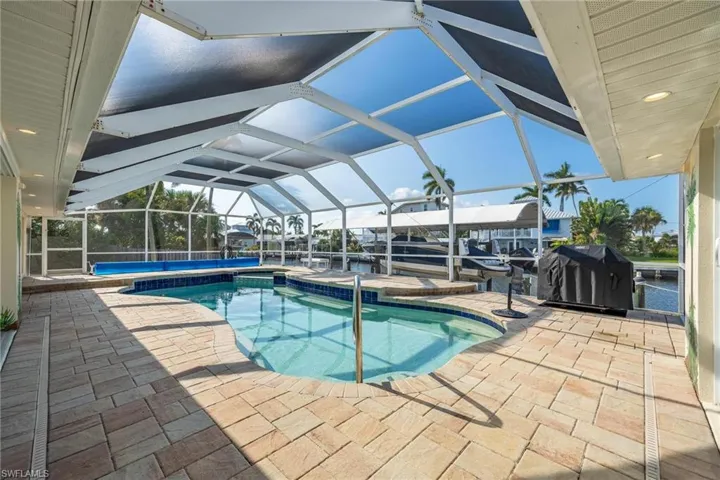 View of pool featuring a lanai, a jacuzzi, and a patio area
