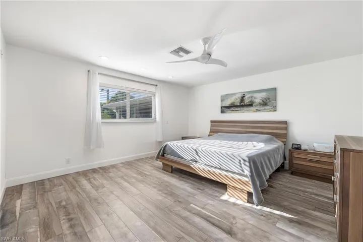 Bedroom with ceiling fan and hardwood / wood-style floors