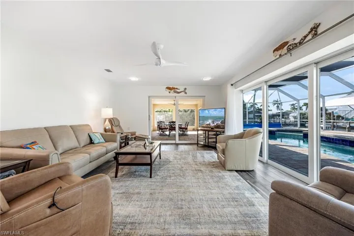 Living room with ceiling fan and light hardwood / wood-style flooring
