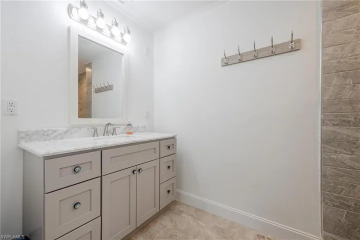 Bathroom with vanity, ornamental molding, and tile patterned flooring