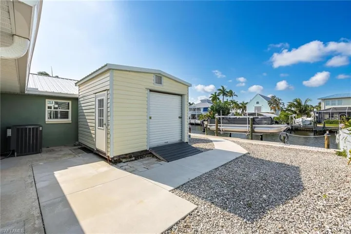 View of outbuilding featuring central AC unit and a water view