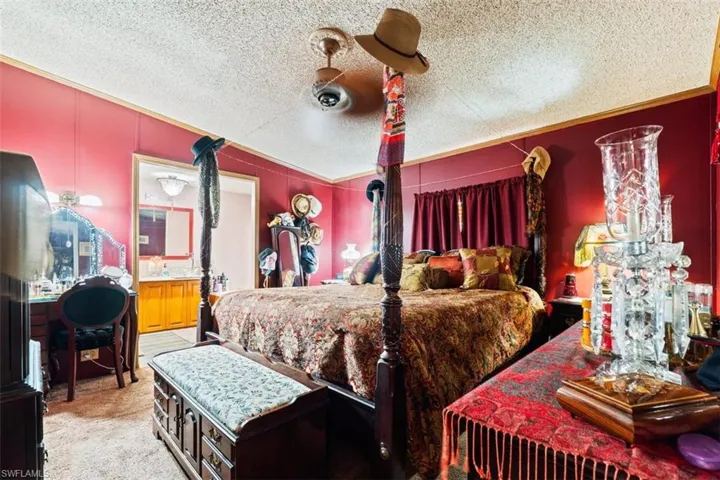 Bedroom with light carpet, a textured ceiling, and ceiling fan