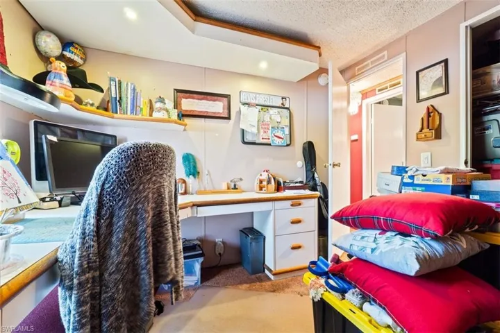 Office featuring light carpet and a textured ceiling