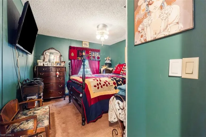 Bedroom featuring a textured ceiling and light carpet