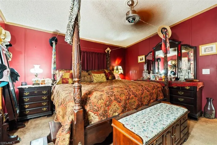 Bedroom with light colored carpet and a textured ceiling