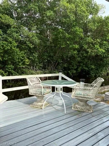 Expansive wooden deck featuring a white railing and tranquil water views