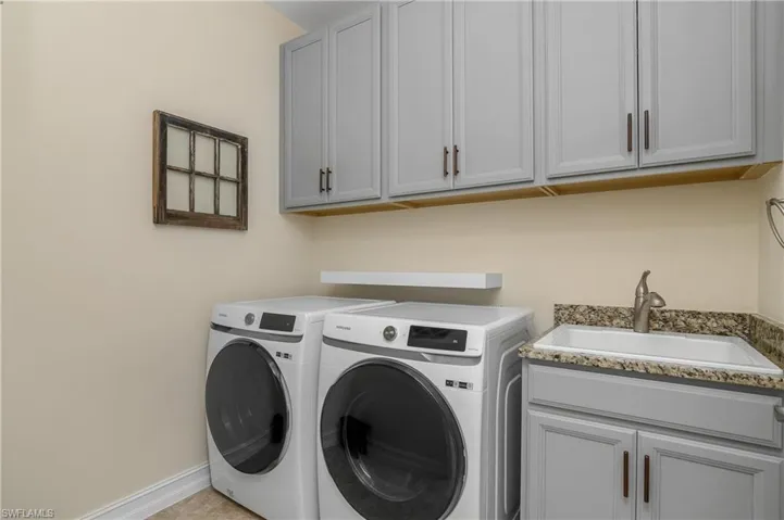 Laundry area with gray cabinets, washing machine and dryer, (new in 2024) and sink
