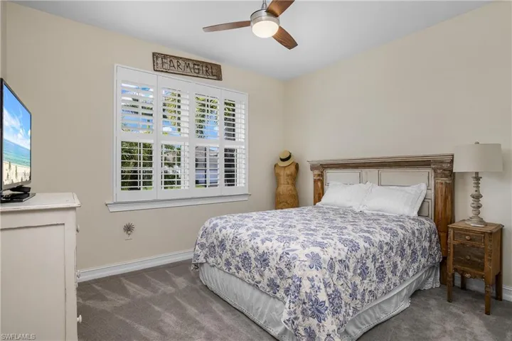 Carpeted bedroom featuring ceiling fan
