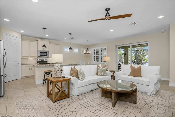 Tiled living room featuring ceiling fan (furniture is optional)